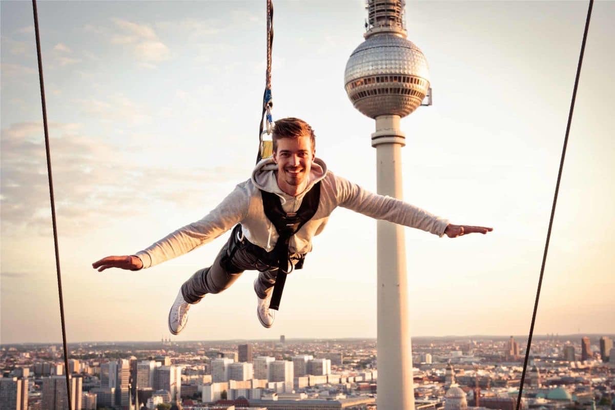 Mann hängt lächelnd am Base Flyer mit dem Fernsehturm Berlins im Hintergrund