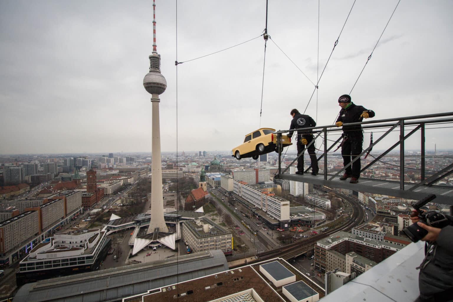 Auto wird am Base Flyer in Berlin eingehängt mit dem Fernsehturm im Hintergrund